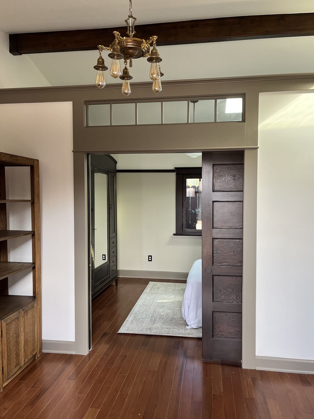 Bedroom of a Craftsman ADU with original-style pocket door and transom