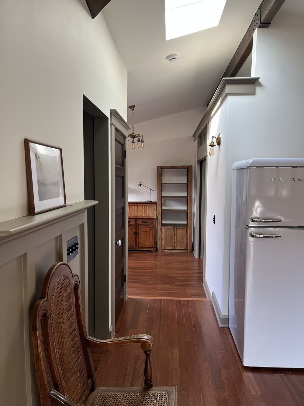 Craftsman ADU hallway under a skylight looking through to the bedroom